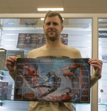 Luke Badger holding up his event playmat